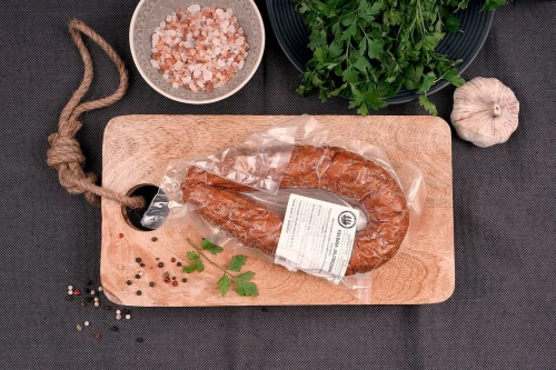 Kiełbasa jałowcowa z dziczyzny na desce - wędzona wędlina z jelenia i dzika