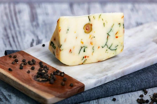 Pecorino Primosale z oliwkami, kaparami i rukolą – włoski ser owczy na desce z dodatkami